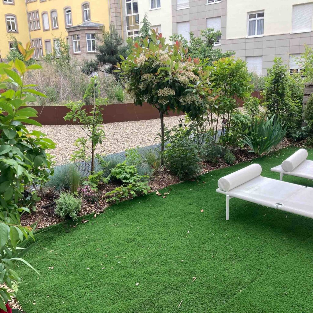 Jardin avec pelouse synthétique et plantes.
