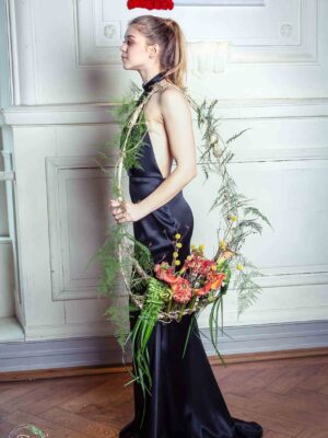 Femme en robe noire avec fleurs.