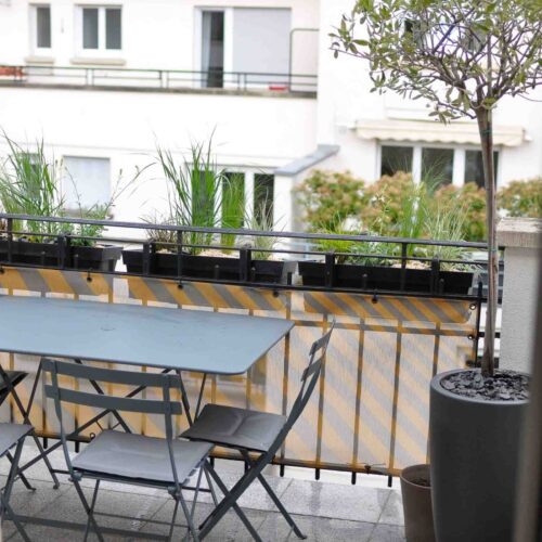 Balcon avec table et plantes.