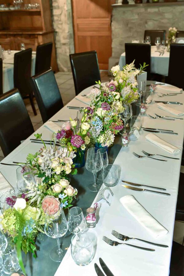Centtre de table de plein de pot de confiture avec différantes variétées de fleurs de jardin